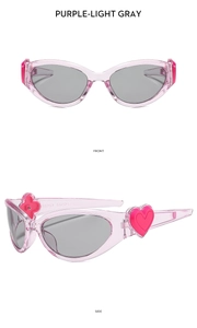 Detail view of oval purple sunglasses featuring pink heart accents on the temple hinges