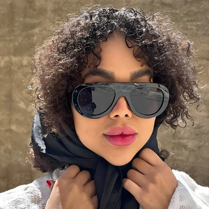 Lunettes de soleil ovales noires oversize tendance sur mannequin pour un style extérieur