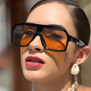 Retro oversized square aviator sunglasses with black frames and orange lenses on a model