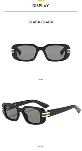 Detailansicht der schwarzen rechteckigen Sonnenbrille mit eleganten Goldakzenten