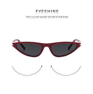 Detailed view of red cat-eye sunglasses with silver metal hinges and dark polarized lenses