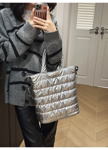 Close-up of metallic silver quilted tote bag showing padded texture and handle detail