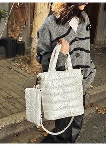 Detail of a white quilted down-style tote bag with detachable small pouch and nylon strap