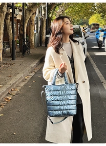 Close-up of blue metallic quilted puffer tote bag with adjustable shoulder strap and texture