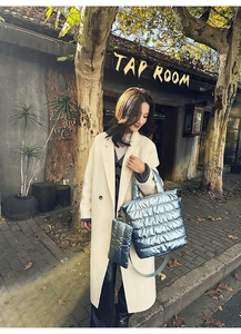 Close-up of quilted padded handbag in metallic blue finish with street style aesthetic