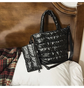Detail view of black quilted puffer tote bag with detachable small pouch and shoulder strap