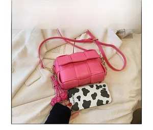 Détail du mini sac bandoulière tressé rose rouge avec chaîne et breloques de mode
