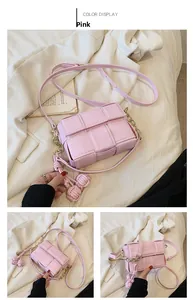 Détail du sac bandoulière rose tressé avec chaîne dorée et breloque pompon