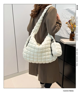 Detailed view of white quilted puffer shoulder bag with round coin purse and soft textures