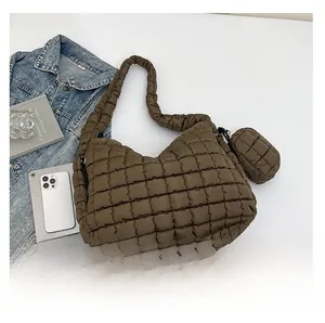 Detail of brown quilted puffer shoulder bag with detachable mini pouch and crescent shape