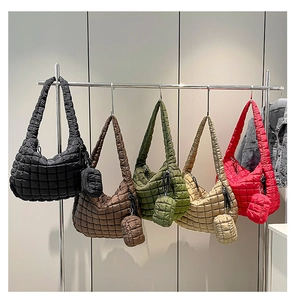 Detail view of five color quilted cloud bags with matching small pouches on metal rack