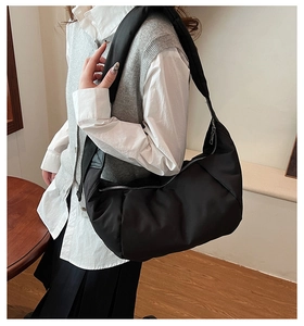 Detailed view of black nylon crescent bag on model showing large capacity and soft texture