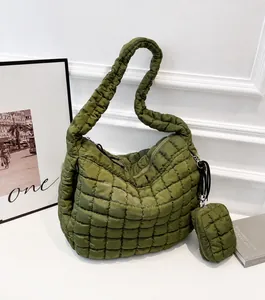 Detail of army green quilted tote bag featuring a matching round coin purse and metal D-ring
