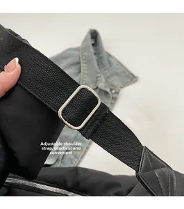 Détail de la bandoulière réglable en nylon noir avec boucle en métal argenté poli