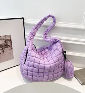 Close-up of purple quilted cloud bag with matching mini round coin purse detail