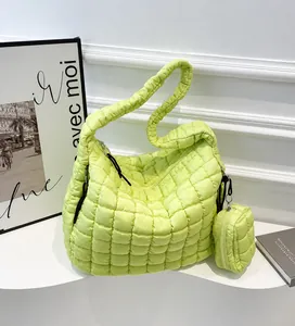 Detail of green quilted cloud tote bag featuring matching coin purse and soft padded strap