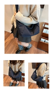 Detail view of large dark blue crescent crossbody bag with nylon padded texture