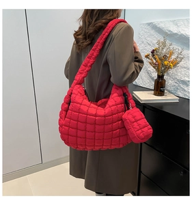 Detail of red quilted puffer tote bag with matching mini pouch and wide strap