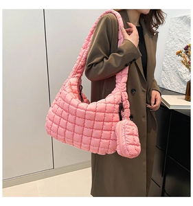 Quilted pink cloud bag with matching round coin purse shown in a lifestyle street shot