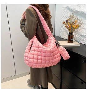 Close-up of pink quilted puffer shoulder bag with a matching mini round coin purse