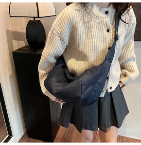 Détail d'un grand sac bandoulière bleu foncé en nylon avec sangle réglable et style décontracté
