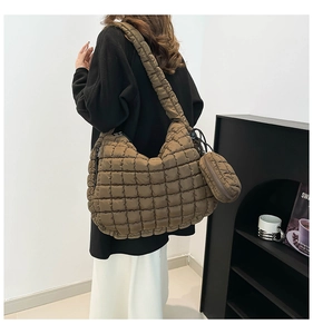 Detail of a dark brown quilted tote bag showing texture and round coin purse attachment