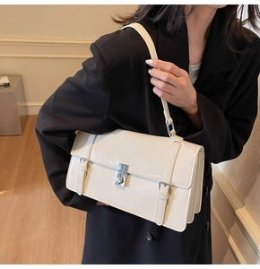 Détail d'un sac à bandoulière en cuir verni blanc crème avec fermoir en métal argenté