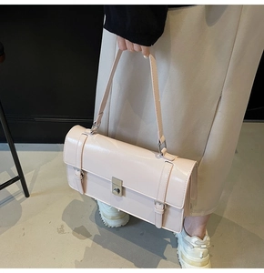 Détail du sac à bandoulière en cuir verni rose clair avec fermoir métallique et boucles décoratives