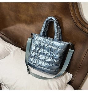 Close-up of metallic ice blue quilted tote bag with detachable crossbody strap and padding