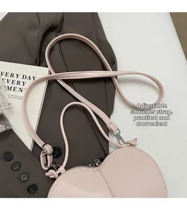 Detail of adjustable shoulder strap on pink heart bag with silver metallic buckles