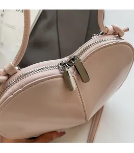 Detailed close-up of smooth silver dual metal zippers on a pink heart-shaped bag