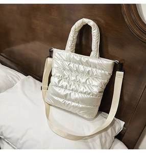 Detail of quilted puffer tote bag with glossy pearl finish and detachable shoulder strap