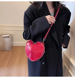 Detail of red heart-shaped shoulder bag with glossy patent leather and silver zipper