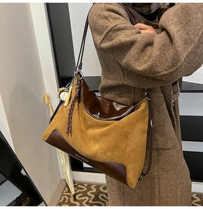 Detail view of mustard yellow suede tote bag with Moon Shark brand logo on brown leather base