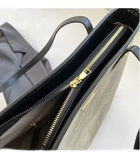 Dettaglio della cerniera in metallo dorato e fodera interna di una borsa tote chic