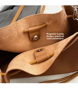 Detailed macro view of the brown leather bucket bag featuring a secure magnetic clasp design