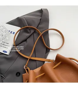Detail view of the caramel brown leather bucket bag with an adjustable shoulder strap