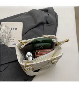 Vue intérieure du sac matelassé blanc montrant le rangement du mobile et du portefeuille