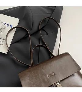 Detailansicht der dunkelbraunen Ledertasche mit feinen Nähten und schmalen Trägern