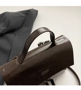 Detailansicht des braunen Ledergriffs mit hochwertigen Kontrastnähten im Retro-Stil