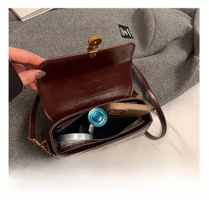 Detail showing the internal storage and compartments of a vintage dark brown leather bag