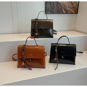 Drei Retro-Handtaschen aus Kunstleder in Braun, Schwarz und Grün mit Glockenanhängern