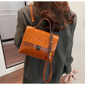 Détail d'un sac à main en cuir verni marron vintage avec fermoir rotatif sur velours vert