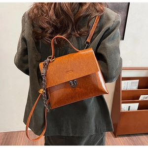 Detailansicht der braunen Vintage-Lederstruktur und der Metallschnalle der Handtasche