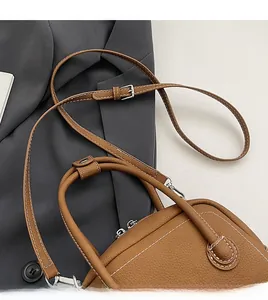 Detail of brown litchi pattern bag with white stitching and silver metal buckle
