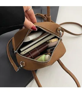 Interior view of brown pebble leather bag showing storage for phone and cosmetics