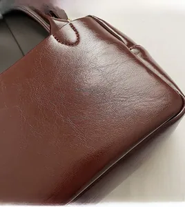 Détail du cuir ciré marron foncé avec texture naturelle souple et coutures fines