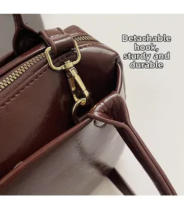 Détail du sac en cuir marron brillant montrant le crochet doré amovible robuste