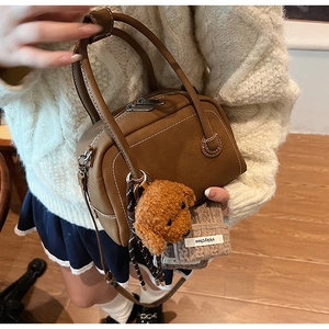 Sac bowling en cuir marron foncé avec surpiqûres blanches et charme chien en peluche