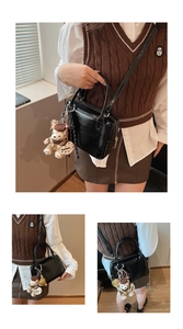 Détail du sac carré noir en cuir PU brillant avec un pendentif ours en peluche mignon